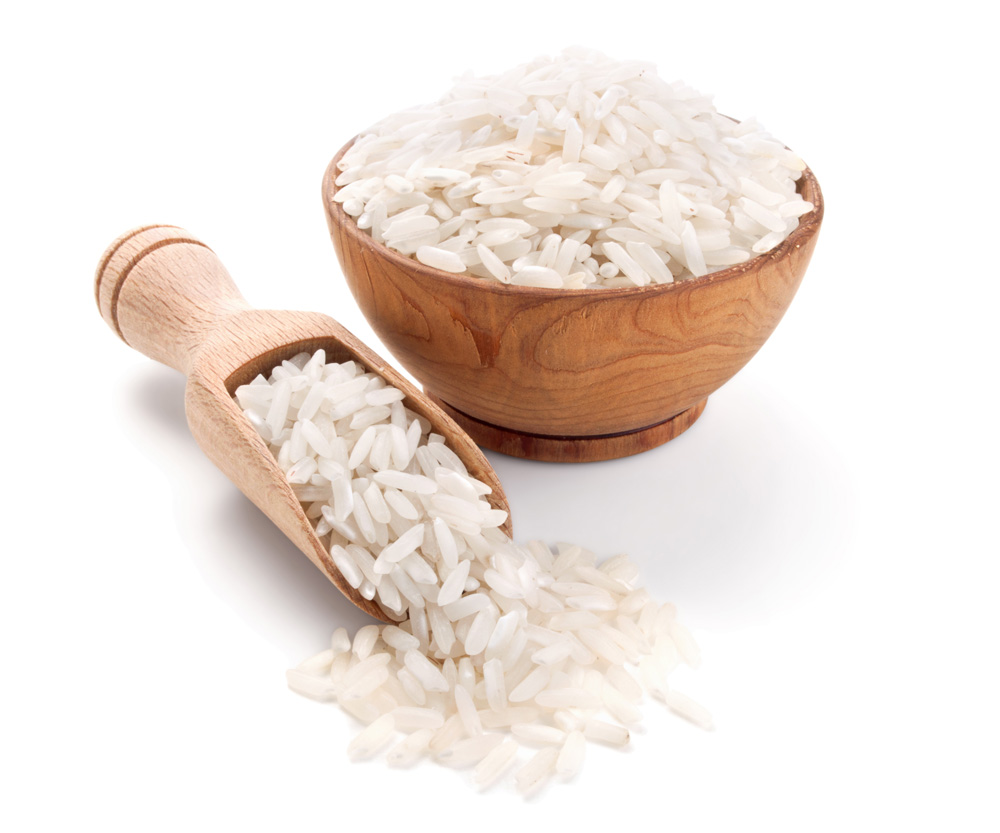 long grain rice in a wooden bowl isolated on white background