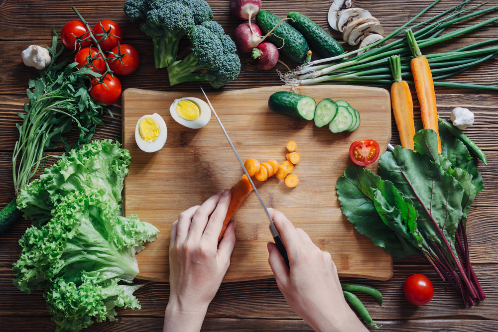 Healthy food and ingredients with tomato, salad, arugula, carrots, beet, beetroot, leaves, cucumber, onion, green, radish, mushrooms, garlic, broccoli, half, egg and peas on rustic wooden background, top view