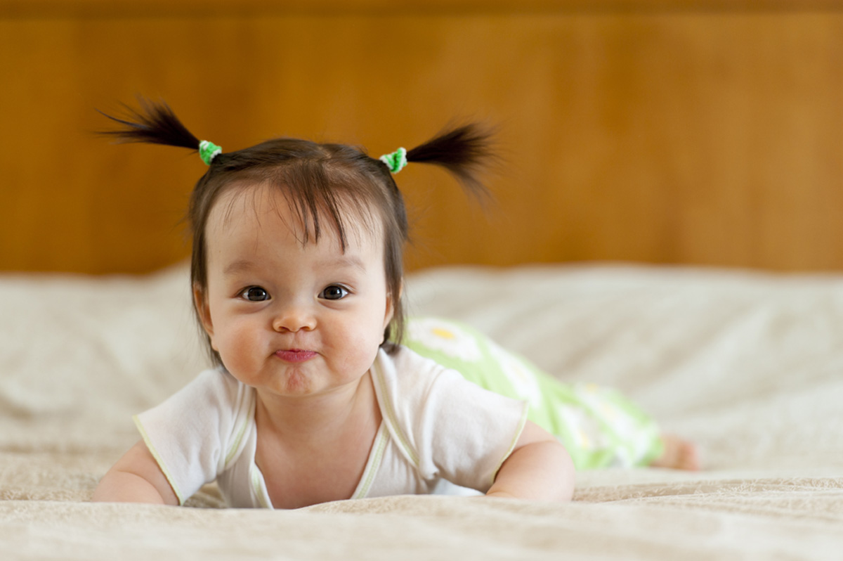 Baby tummy time with funny facial expression